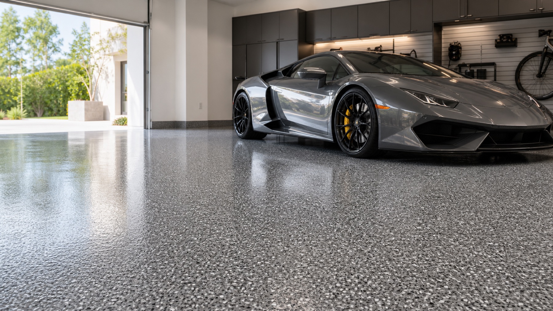 A silver supercar parked on a freshly coated grey flake epoxy garage floor